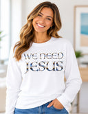 Woman wearing white We Need Jesus long sleeve white tee featuring Aruba sunrise-filled lettering