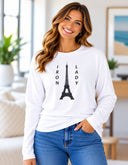 model wearing Women’s long sleeve Iron Lady white tee featuring an Eiffel Tower photograph captured in Paris, France