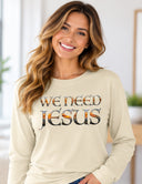 Woman wearing butter We Need Jesus long sleeve tee featuring Mount Dora Florida sunset lettering