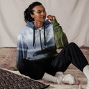 Sitting front view of female model in zip-up hoodie with full-scene Cliffs of Moher coastal print, front zipper, drawcord hood