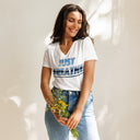 front white Women’s V-neck Just Breathe tee with lettering filled with a scenic Alaska water and mountain photograph