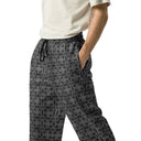 Left front view of male model in unisex wide-leg joggers with monochrome dahlia pattern — Victoria Island Monochrome Charm