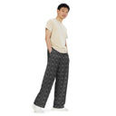 Right front view of male model in unisex wide-leg lightweight pants with monochrome dahlia pattern — Victoria Island Monochrome Charm