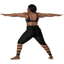 model yoga pose Women’s crossover leggings with pockets featuring a black and bronze architectural print from the Dr. Phillips Center for the Performing Arts in Orlando