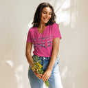 model wearing berry  Women’s We Need Jesus Sunrise V-neck tee with lettering filled with an Aruba sunrise photograph