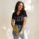 model wearing black Women’s We Need Jesus Sunrise V-neck tee with lettering filled with an Aruba sunrise photograph