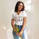 model wearing white Women’s We Need Jesus Sunset V-neck tee with lettering filled with a Mount Dora Florida sunset photograph