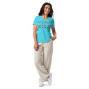 model wearing turquoise Women’s We Need Jesus Sunrise V-neck tee with lettering filled with an Aruba sunrise photograph